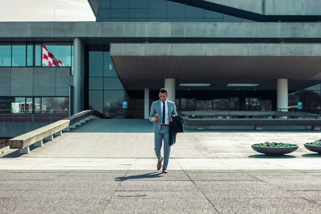 Business executive walking from office building.