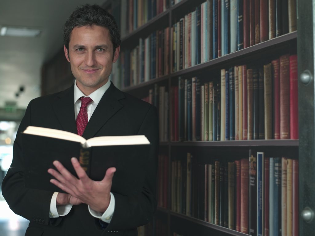 Businessman reading book in library