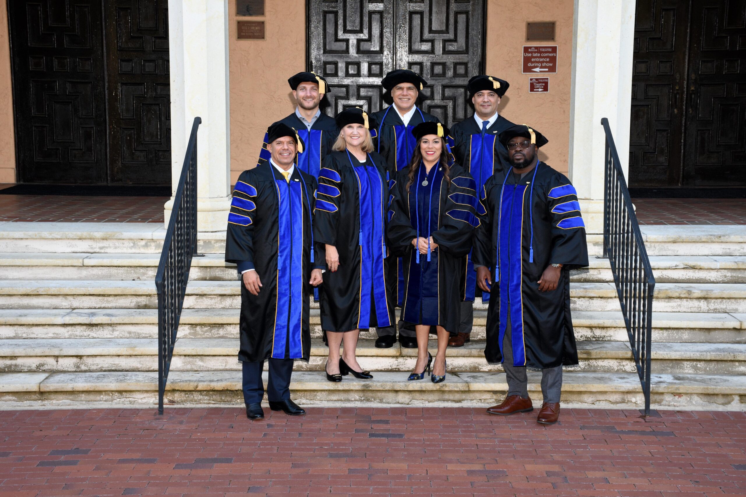 a group of EDBA graduates stand in their commencement regalia on a set of stairs