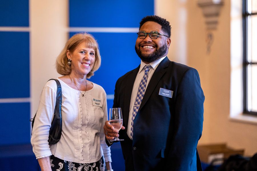 male crummer student smiles standing next to female mentor