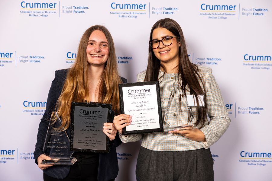 truist distinguished leaders of merit hold their awards in front of crummer banner