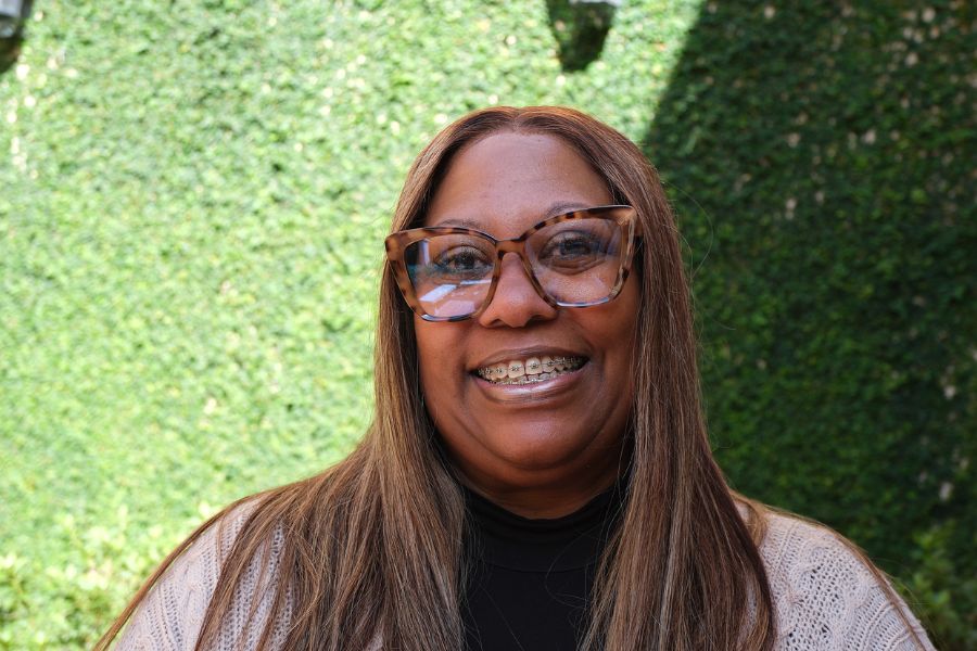 dawn williams smiles in front of vine-clad wall