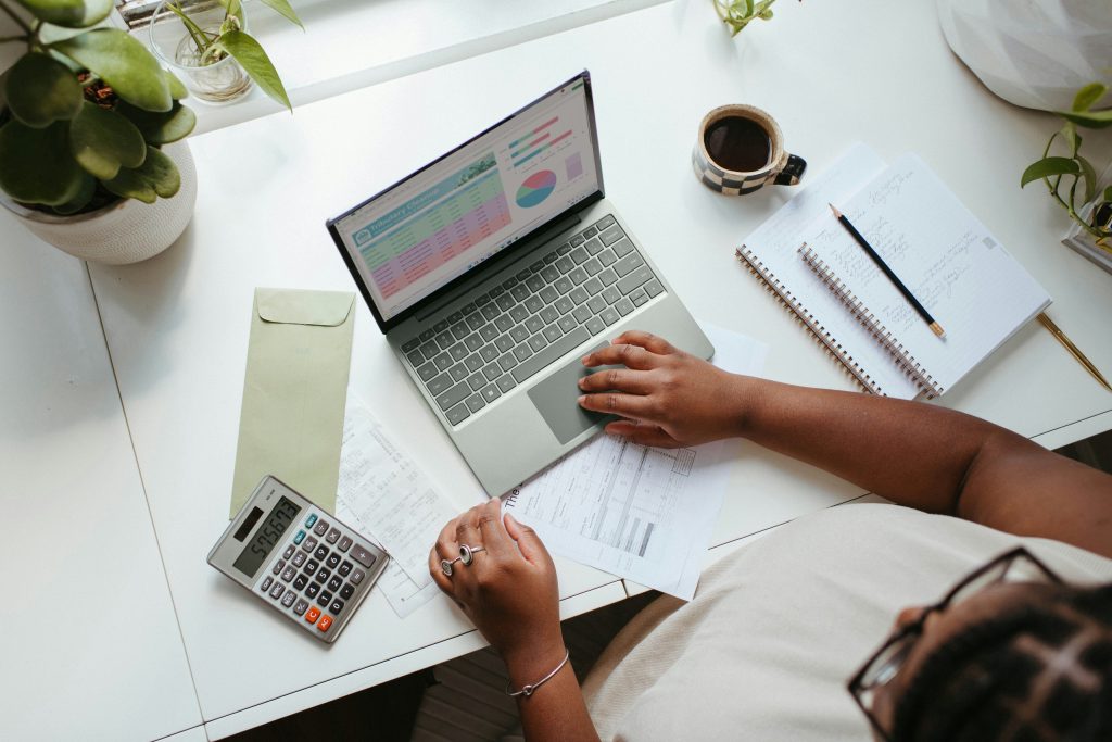 A person working on business financials with a laptop and calculator.