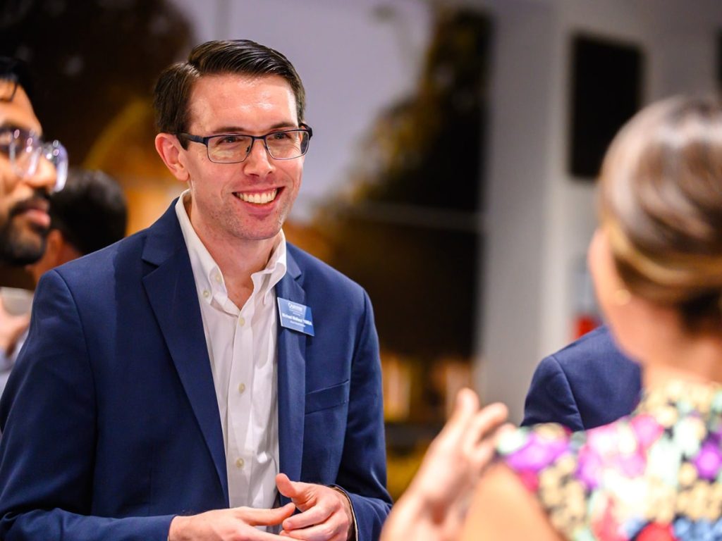 Crummer Alumni Board member engaging alumni at a networking event.