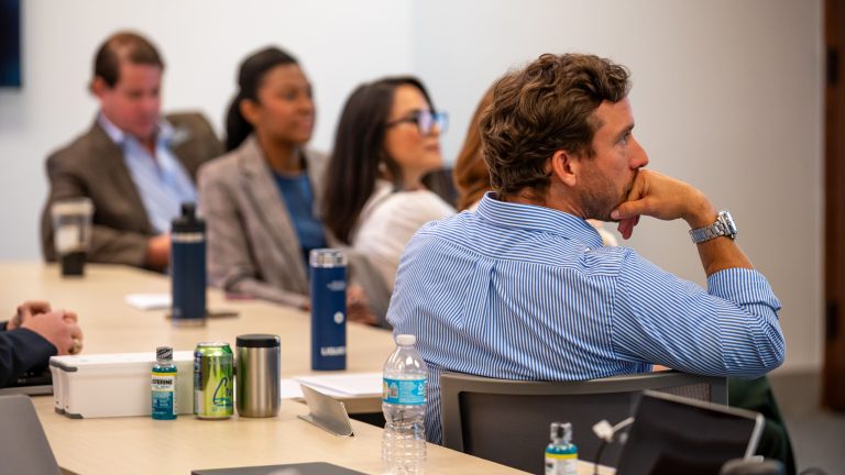 Group of students listening attentively in a business classroom.