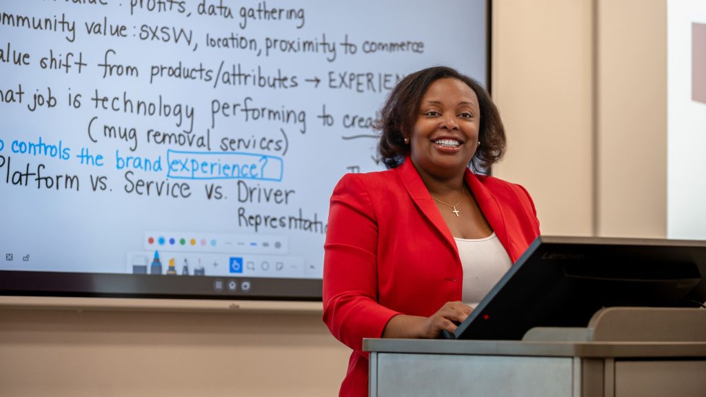 A professor presenting in an academic business setting.